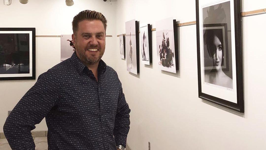 Nathan Harmon posing in front of his exhibit in the OSUIT Conoco Gallery